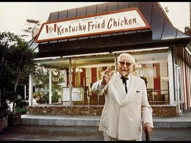 Coronel Sanders frante a un KFC